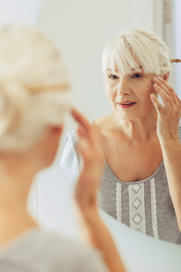 Nice pleasant woman looking into the mirror